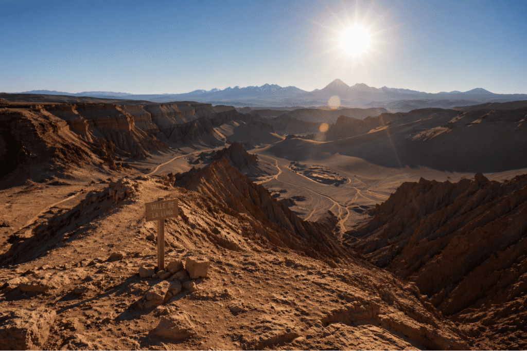 Paisagem avermelhada e formações de sal do Valle de la Luna no Deserto do Atacama sob a luz do pôr do sol. Imagem de roteiro turístico VIP com guias brasileiros e brinde exclusivo.